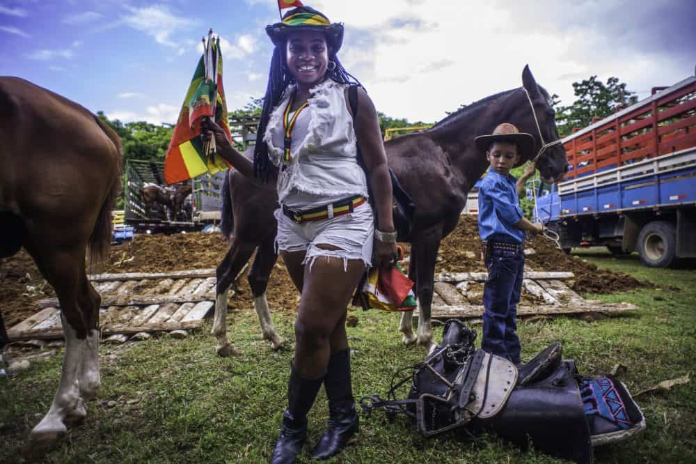 Riders with dreadlocks and colorful attire parading through the streets of Puerto Vie