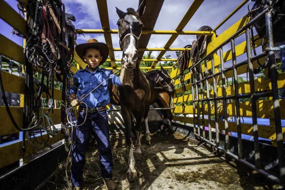 Young rider leading a beautifully decorated horse at the Rasta Tope in Puerto Viejo