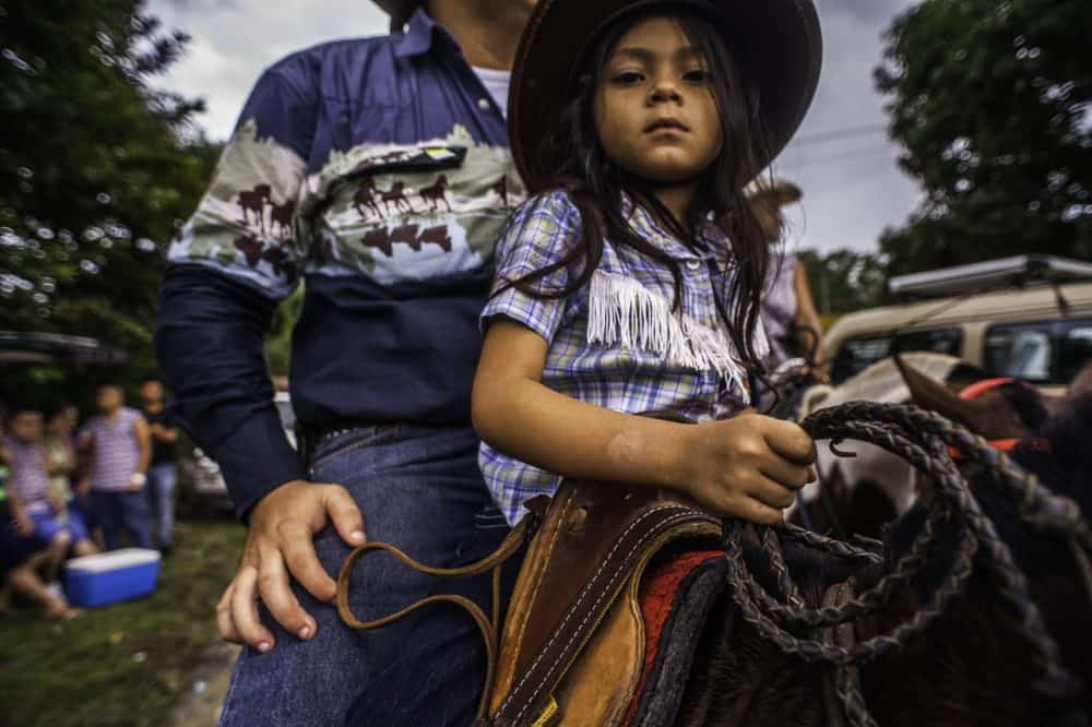 Young rider leading a beautifully decorated horse at the Rasta Tope in Puerto Viejo