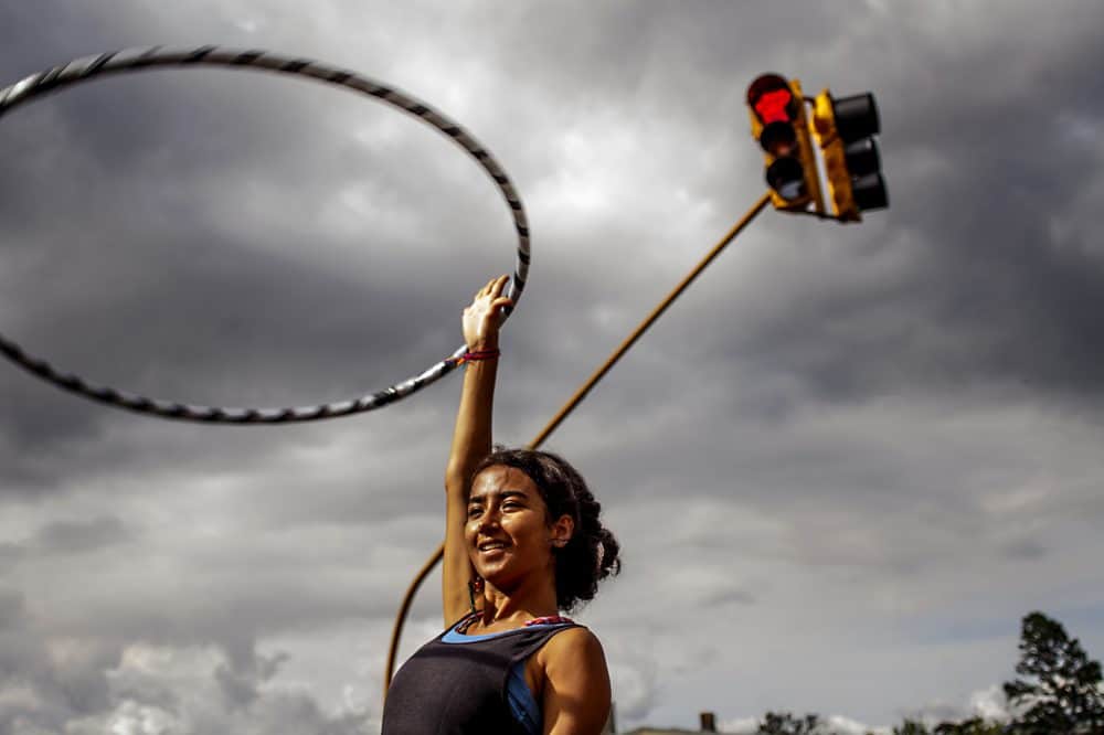 Hula hoop performer in Costa Rica celebrating with onlookers with trick