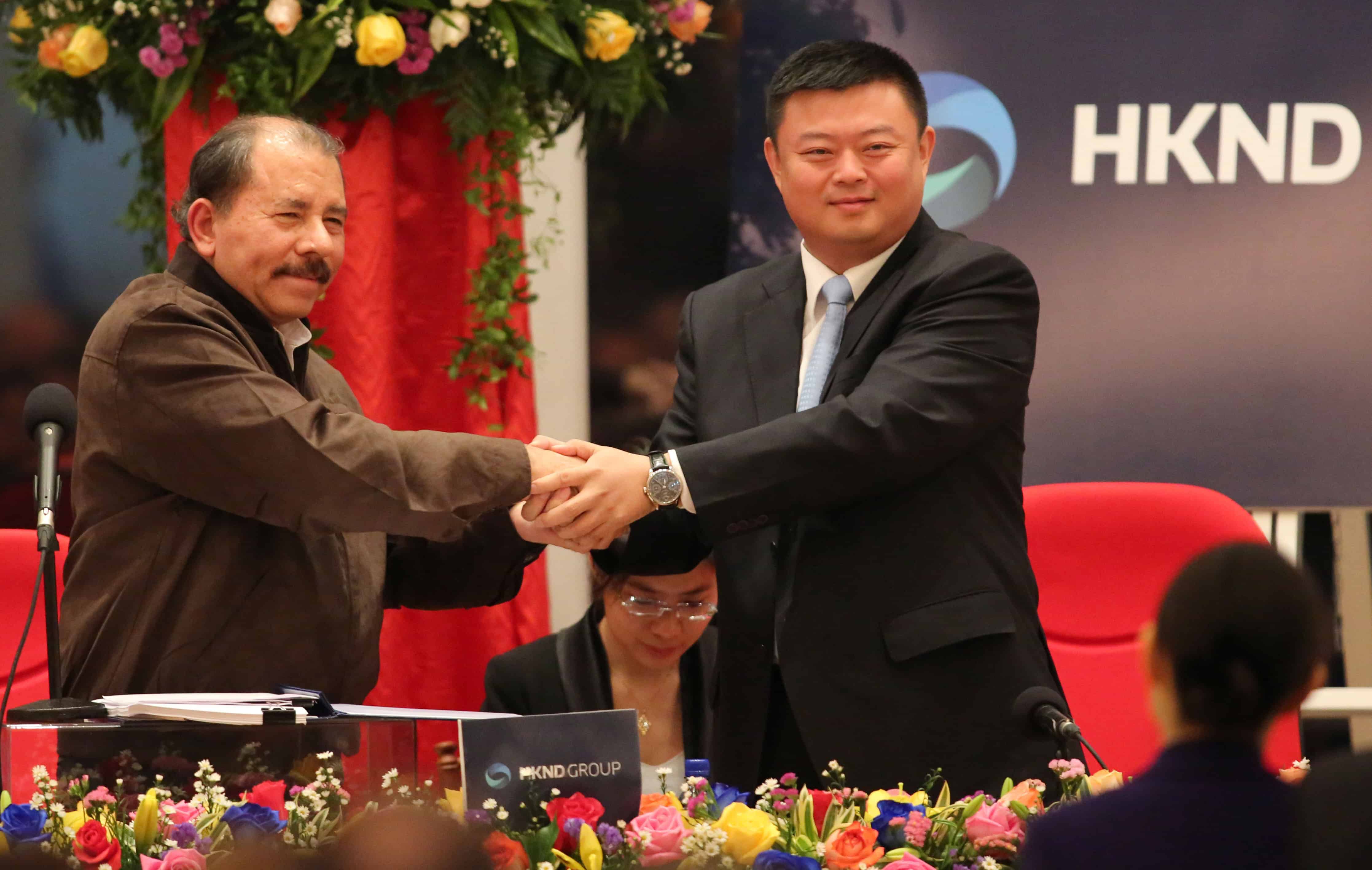 Nicaraguan President Daniel Ortega, left, shakes hands with Wang Jing.