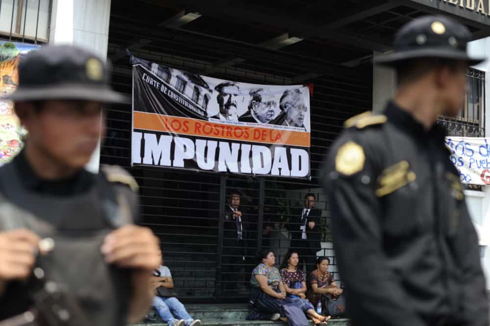 Police guard the entrance of the Constitutional Court of Guatemala during a protest against the quashing of the 80-year sentence for genocide of former Guatemalan dictator General Efrain Ríos Montt on May 24, 2013 in Guatemala City. 