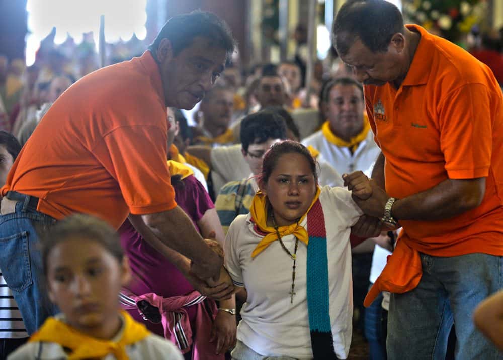 The Costa Rica faithful being helped inside the church, Costa Rica's largest religious event