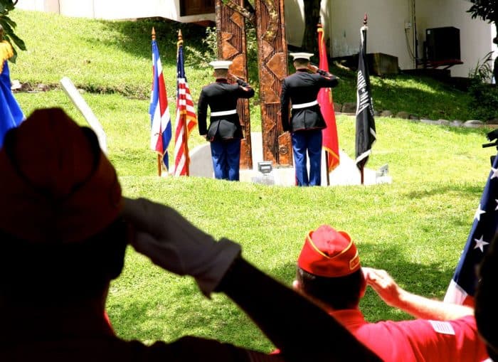 Current and veteran U.S. marines salute the flag at a ceremony commemorating the events of Sept. 11, 2001