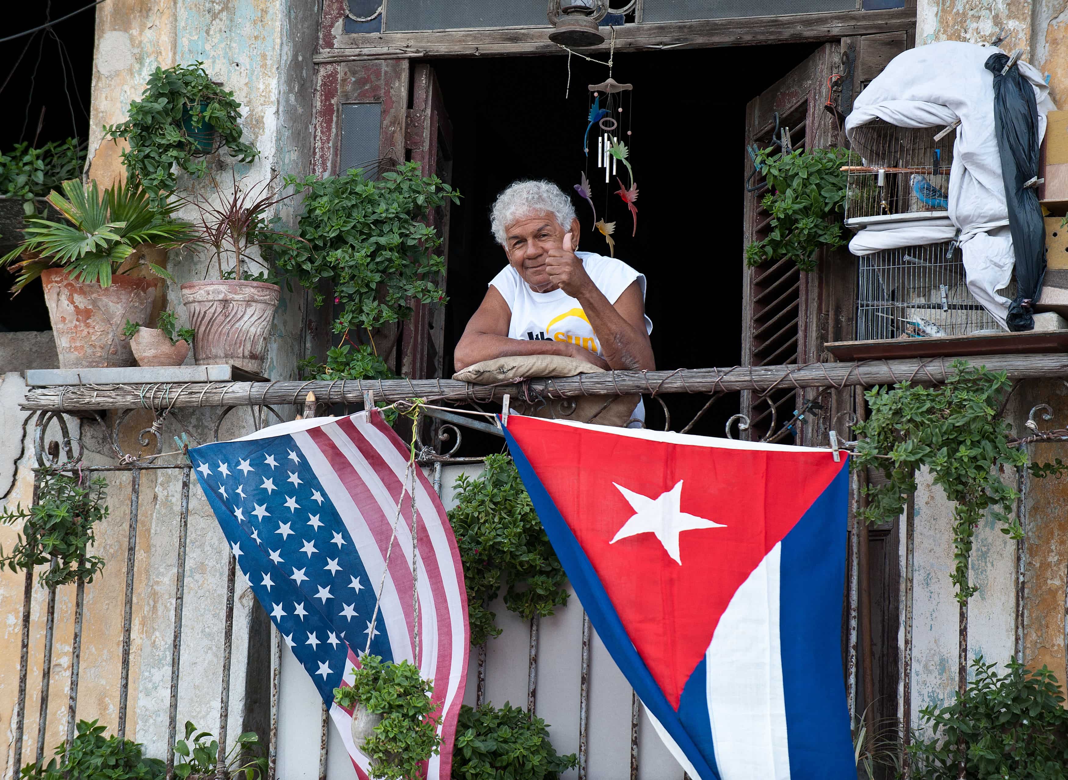A Cuban gives the thumb's up from his balcony decorated with the U.S. and Cuban flags in Havana, on Jan. 16, 2015. The United States eased travel and trade restrictions with Cuba in January, marking the first concrete steps towards restoring normal ties with the Cold War-era foe since announcing a historic rapprochement.