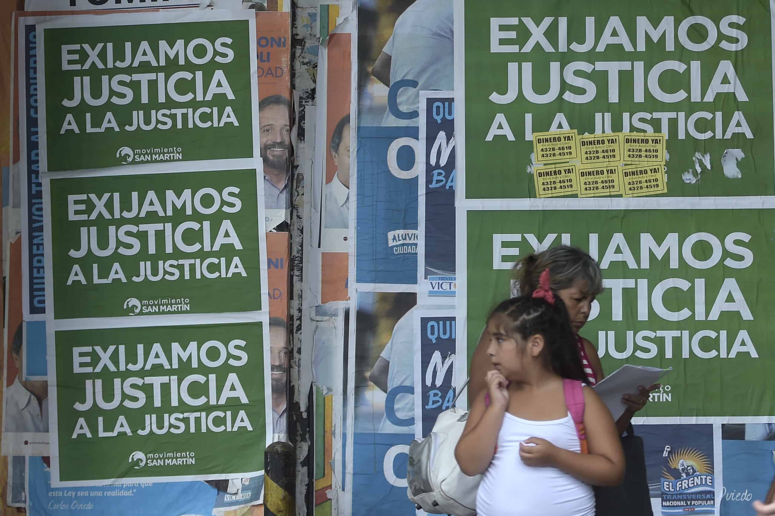 People stand in front of posters reading 