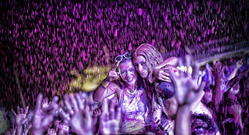 A monsoon of violet paint crashes down on fans at a Life in Color concert.