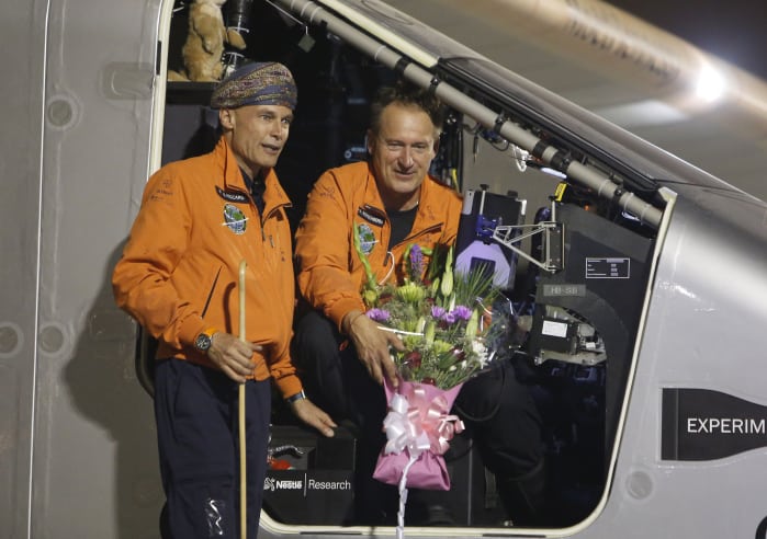 Swiss pilots Bertrand Piccard (wearing a traditional Omani turban) and Andre Borschberg pose for pictures during an official welcome after Solar Impulse 2 landed in the Omani capital Muscat on March 9, 2015.