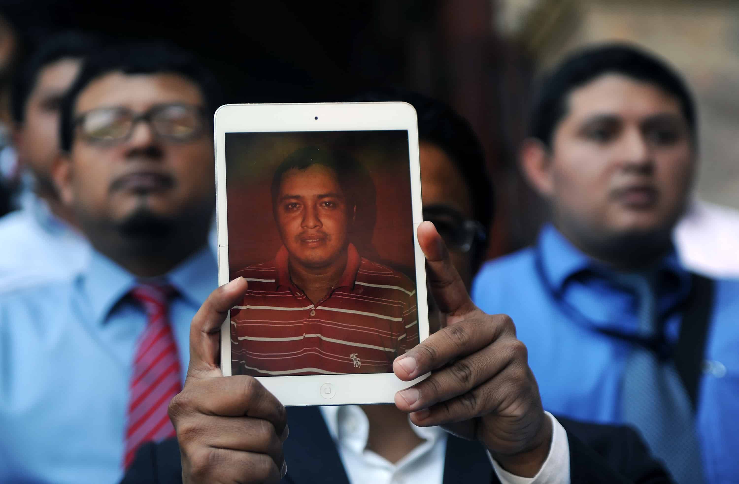 A Guatemalan journalist holds a picture of the late Danilo Lopez during a protest to condemn the armed attack that left two colleagues killed and another injured in the south of the country, in Guatemala City on March 11, 2015.