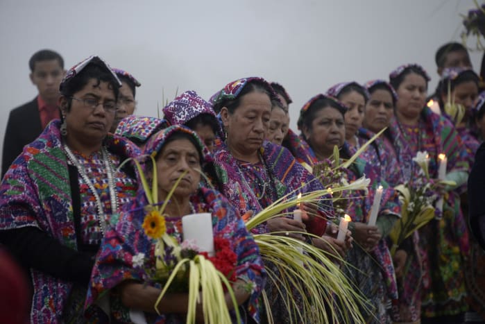 Women in Mayan dress along the procession route.
