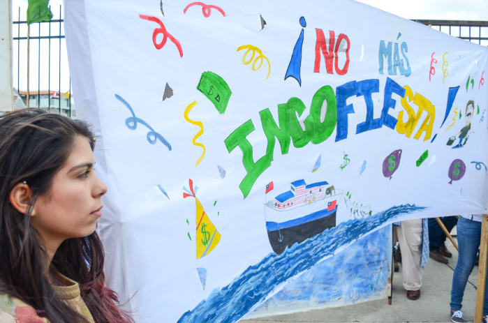 An anti-shark finning protester holds a sign reading "Incofiesta."