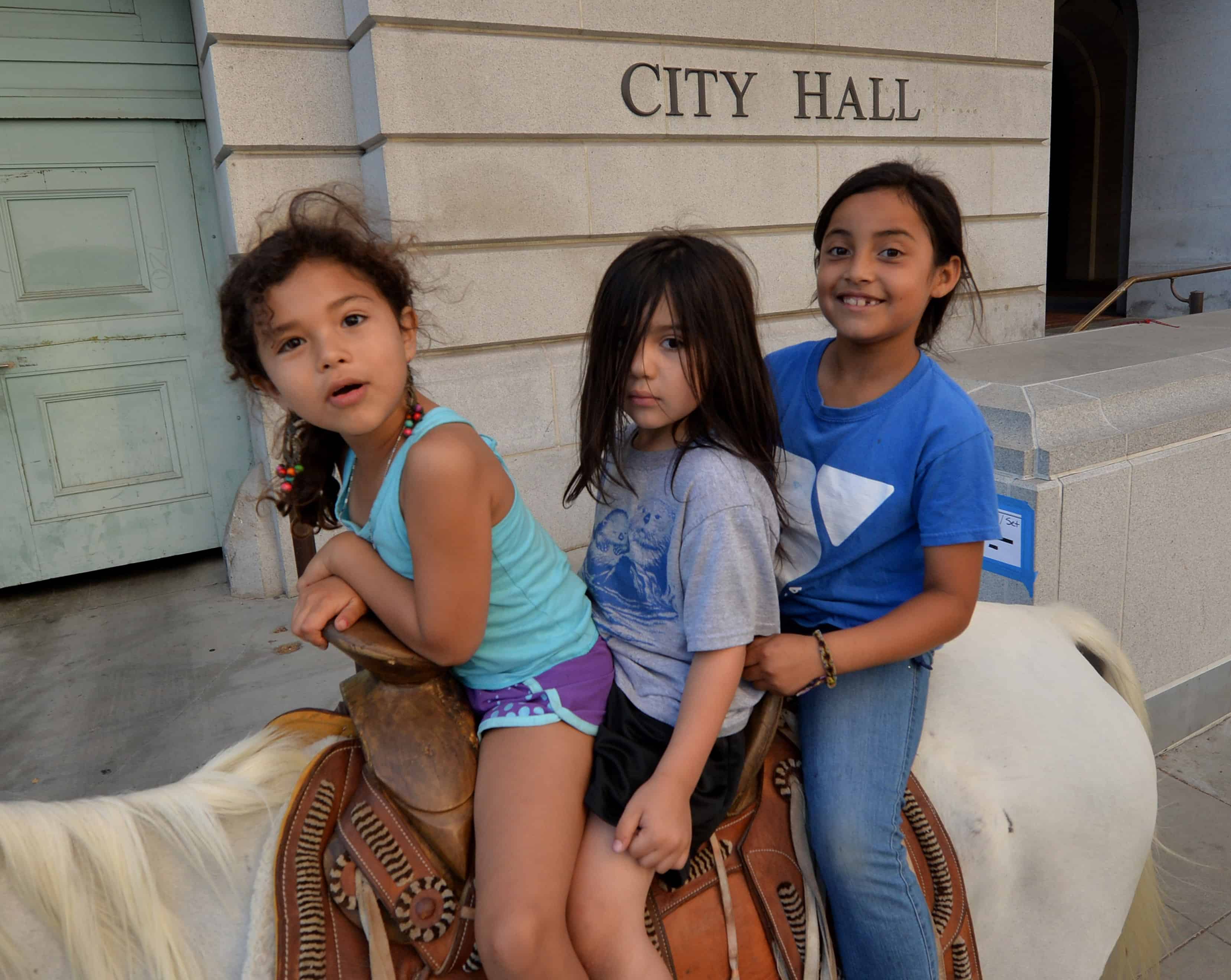 Immigrant children ride a horse past City Hall during a march in Los Angeles as part of the 300-mile 