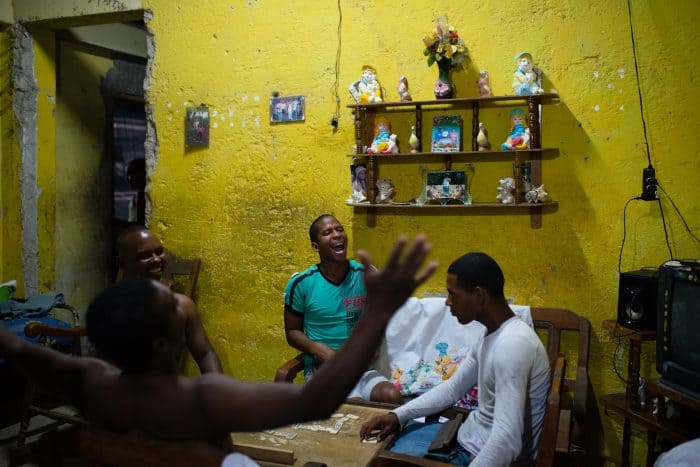 In the poor neighborhood of Juruquey in Camaguey, Cuba, shown on February 3, Yasmany Garcia, 26, in green, screams with excitement at the end of a round of dominos with his friends at his home. Camaguey is Cuba's  third largest city with more than 321,000 residents. 