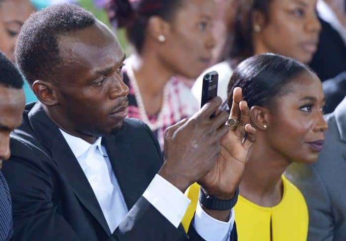 Jamaican sprinter Usain Bolt and sprinter Shelly-Ann Fraser-Pryce watch U.S. President Barack Obama speak.