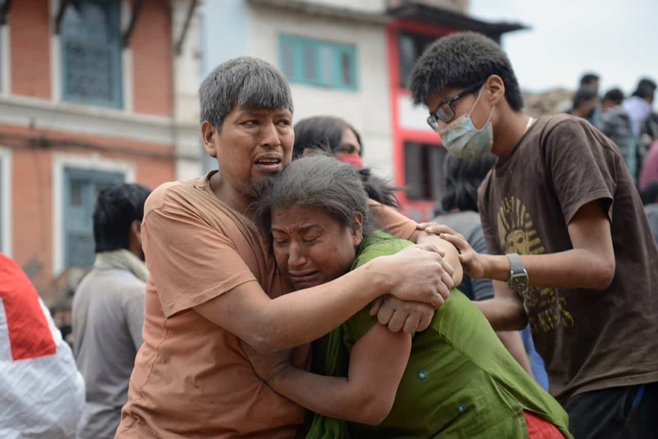 A Nepalese man and woman hold each other in Kathmandu's Durbar Square, a UNESCO World Heritage Site that was severely damaged by an earthquake on April 25, 2015.