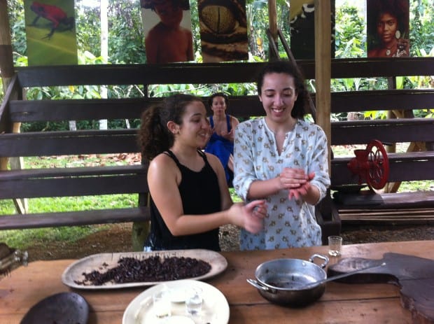 Visitors to Costa Rica knead chocolate into balls as mother Linda looks on.