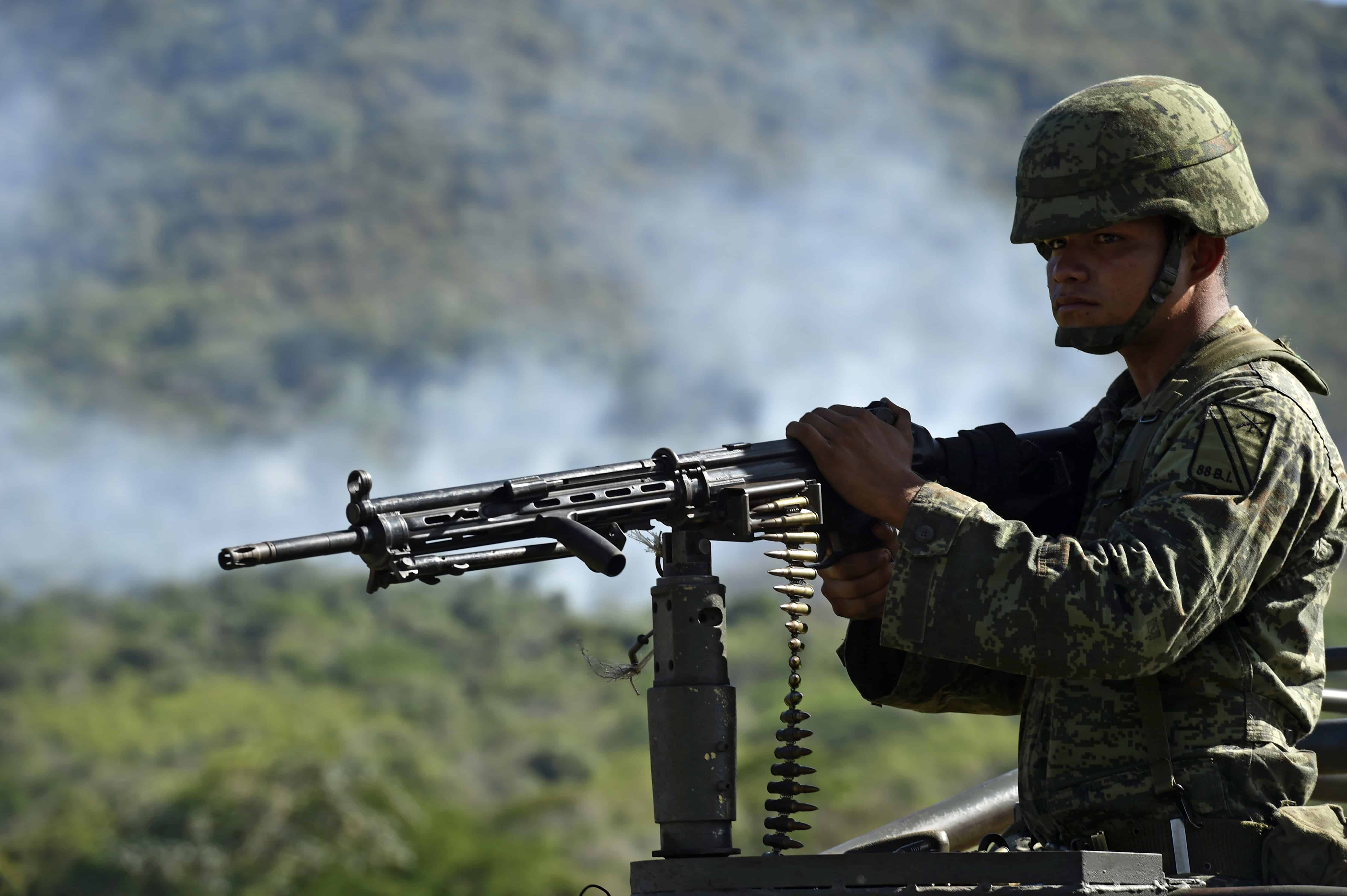 A soldier of the 88th infantry brigade patrols where a military helicopter was shot down in Villa Vieja community, Jalisco, Mexico on May 2, 2015.