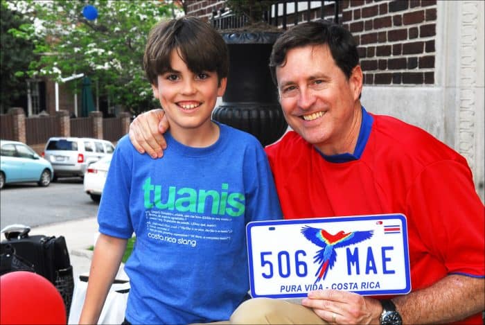 Román Macaya, Costa Rica’s ambassador to the United States, and his 10-year-old son, also named Román, hold up a souvenir license plate for sale.