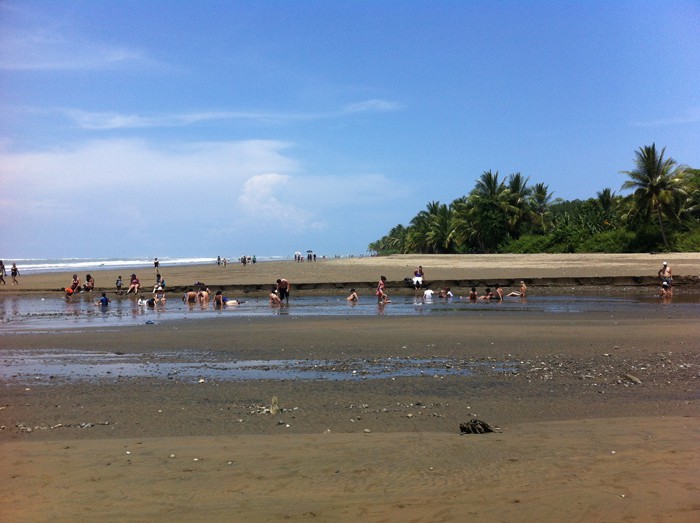 Families get wet in a river at Playa Uvita.