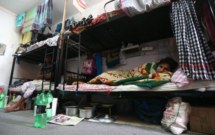 Mubarak, a laborer from Bangladesh, rests in his bedroom at a private camp housing foreign workers in Doha.