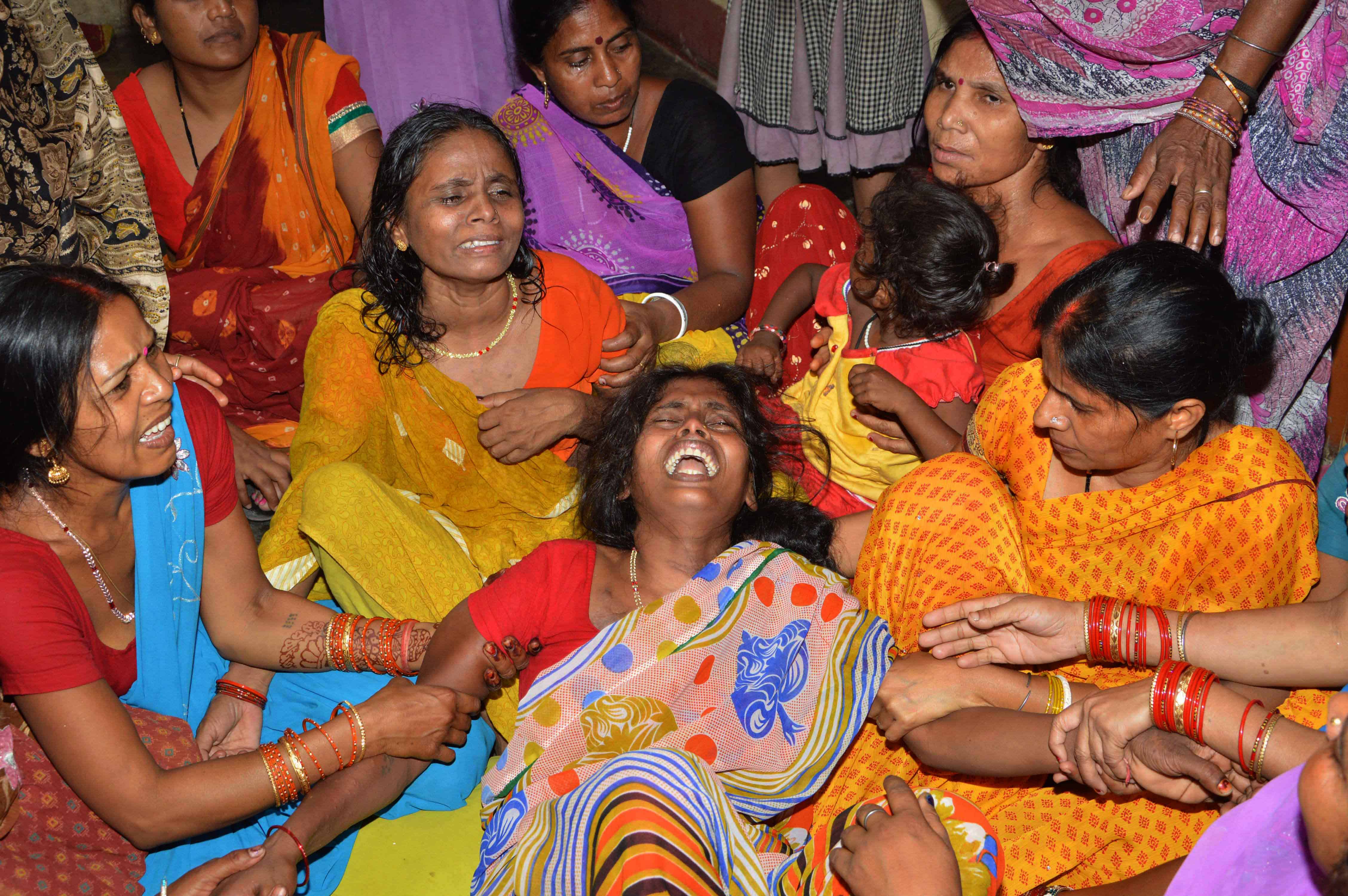 An Indian widow is comforted by relatives and friends.