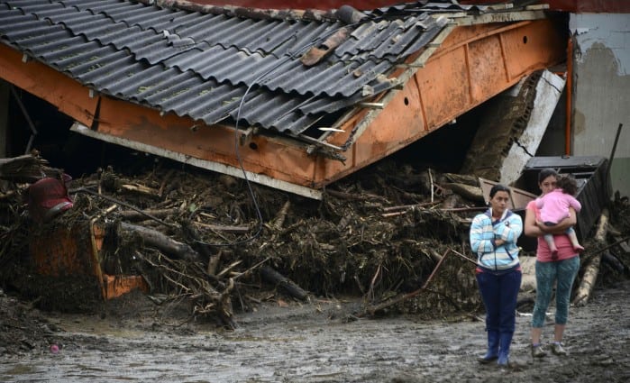 Residents stand next to rubble after a landslide in Salgar Municipality, Antioquia, Colombia, on May 19, 2015.