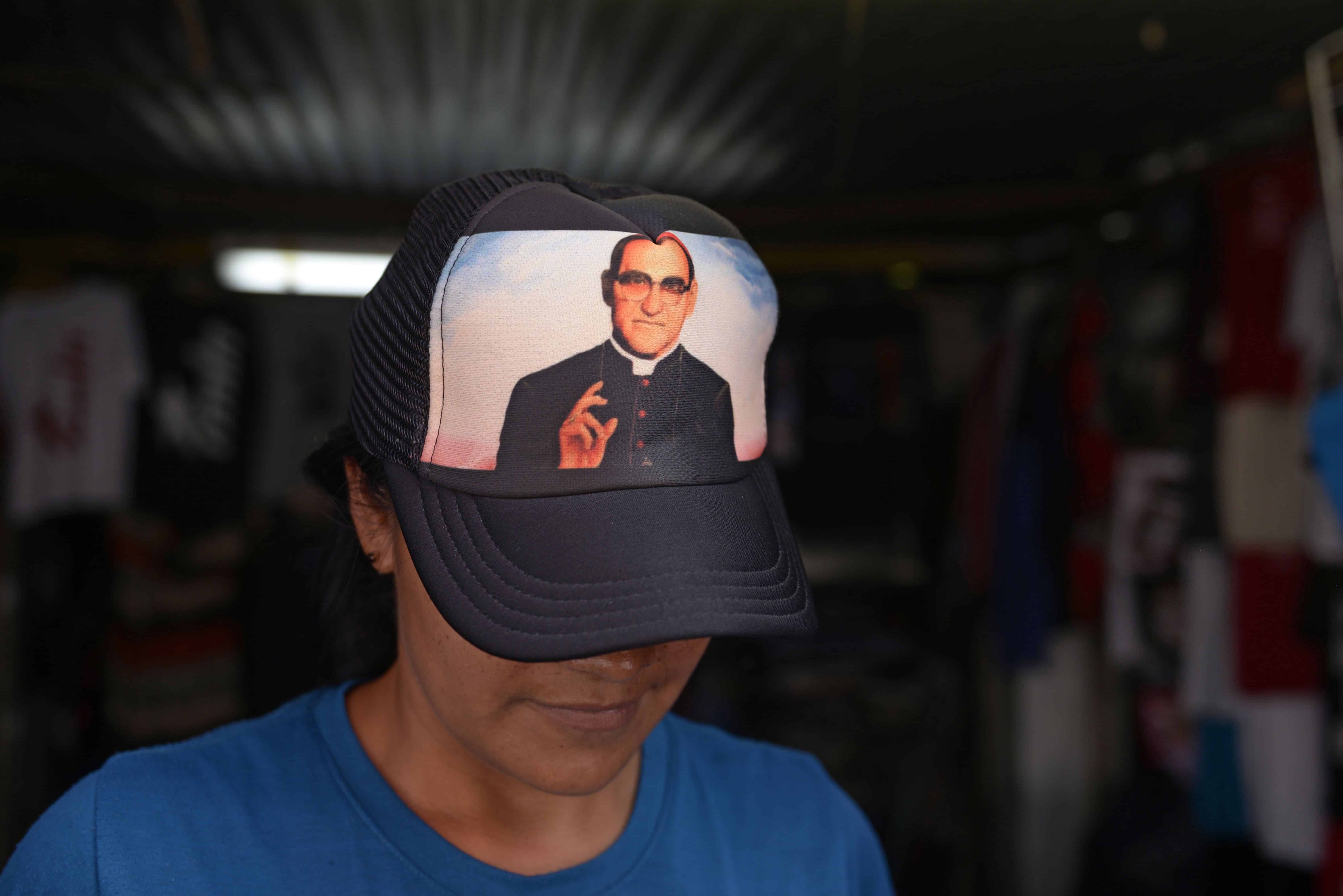 A vendor wears a cap with the portrait of Salvadorean Monsignor Oscar Romero (1917-1980) in San Salvador on May 19, 2015. Monsignor Romero will be beatified next May 23.