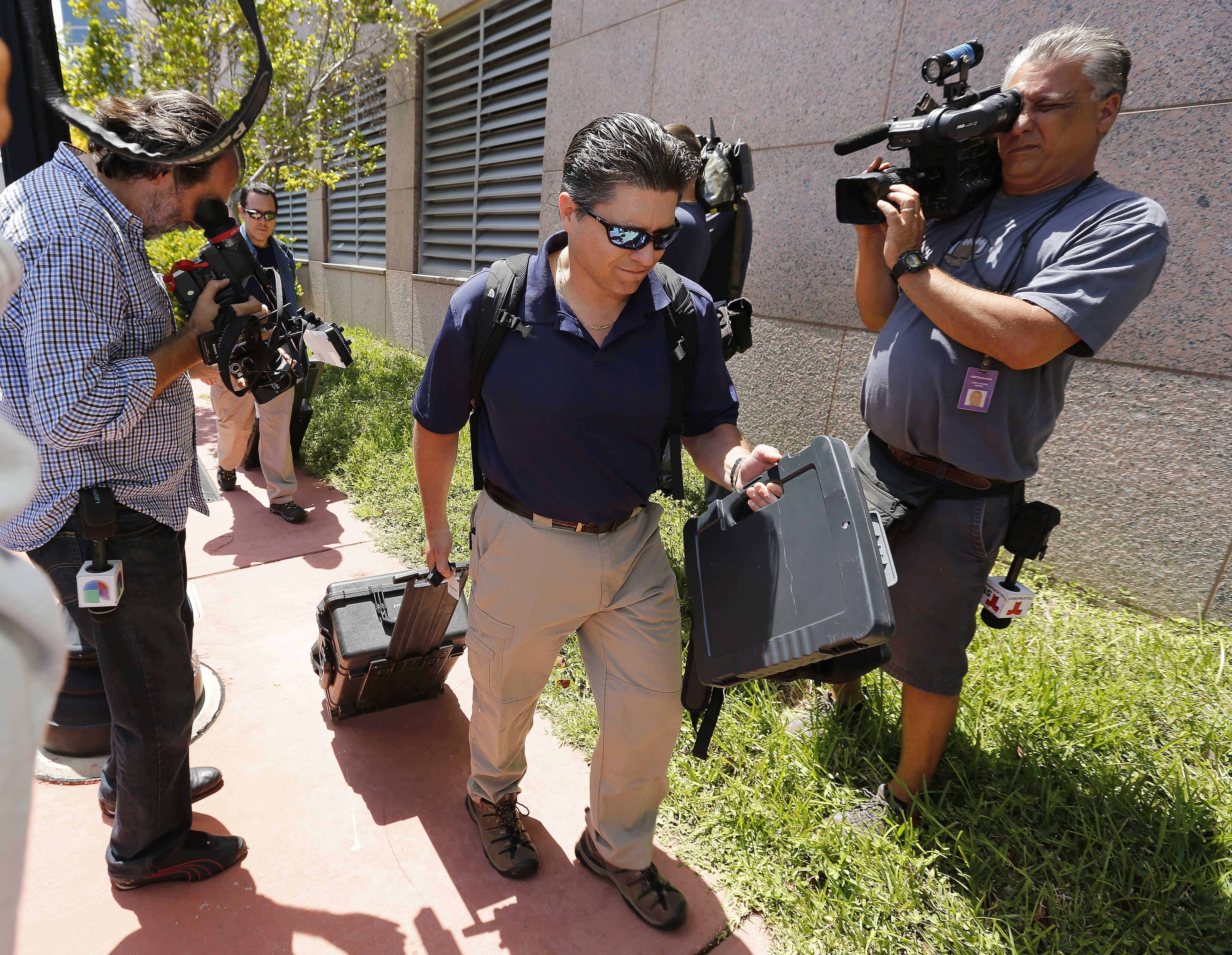 FBI agents exit the headquarters of CONCACAF.