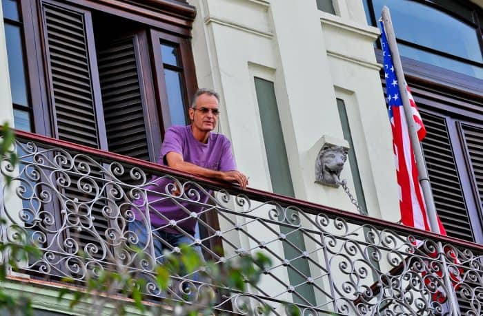 A tourist from the United States looks down from a balcony at the Saratoga Hotel in Havana.
