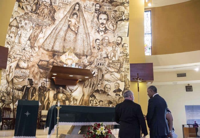 U.S. President Barack Obama speaks with Father Juan Rumin Dominguez as he visits the Shrine of Our Lady of Charity in Miami.