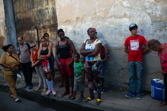 A group of people wait anxiously in Camaguey for public transportation.