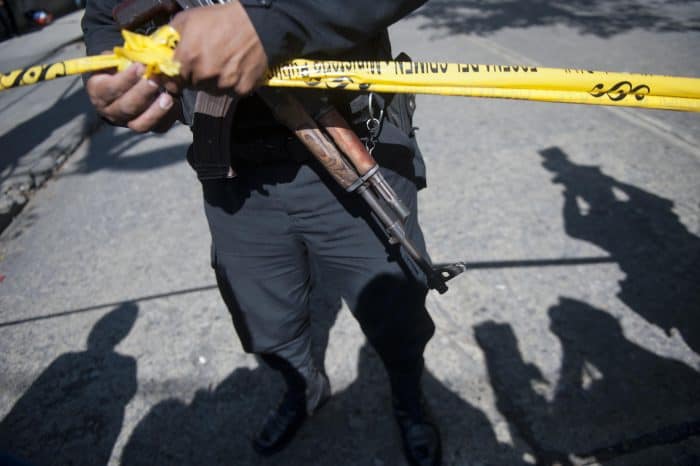 A policeman stands guard at the crime scene after Francisco Palomo, an attorney for Guatemala's former dictator Efraín Ríos Montt, was shot dead.