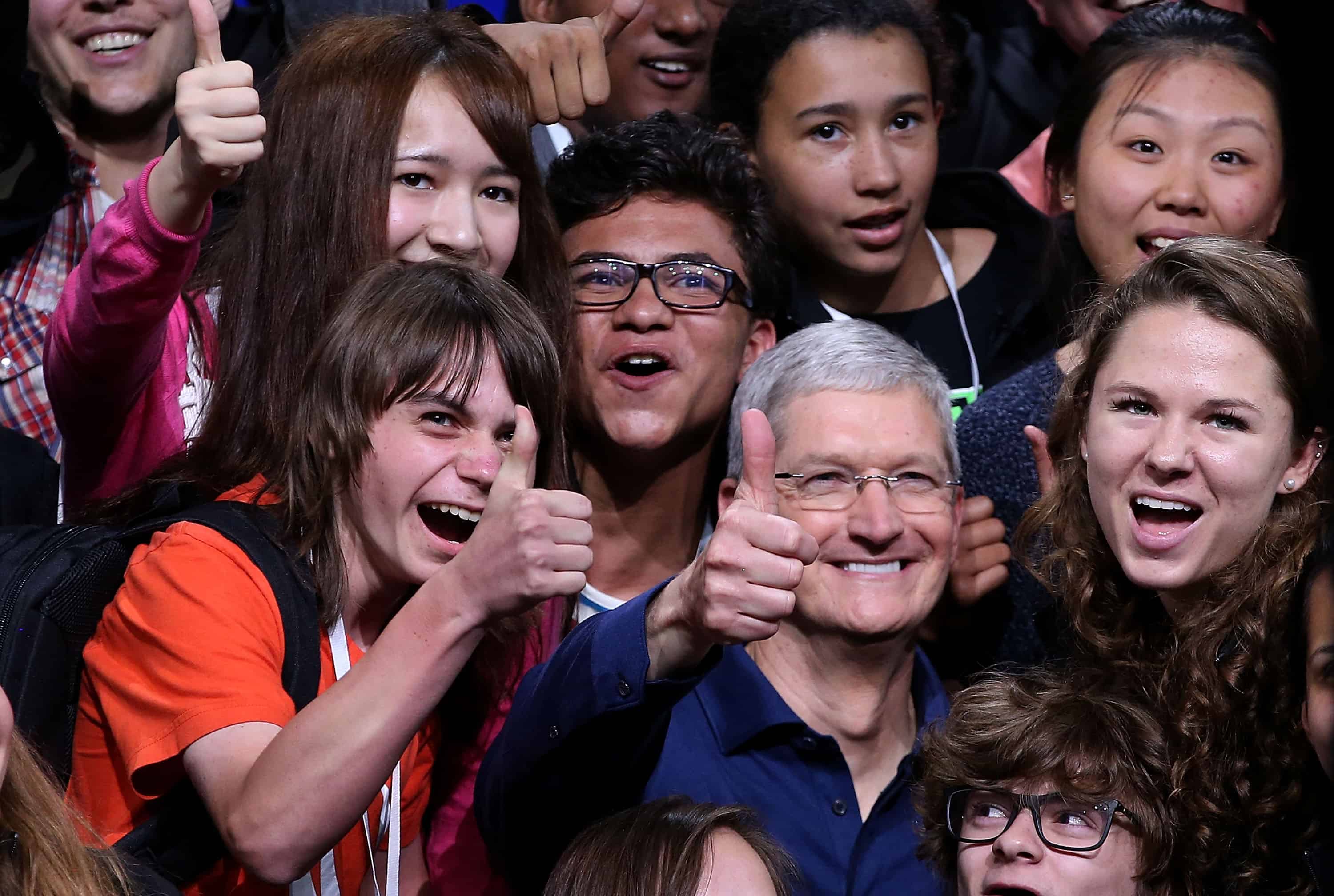 Apple CEO Tim Cook, center, poses for a photo with high school kids.