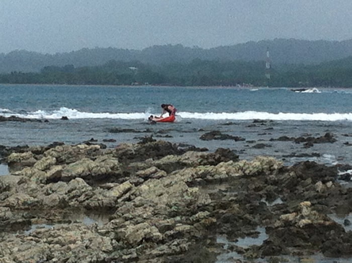Shipwreck! Two men struggle with a kayak that overturned on the rocks of Isla Chora.