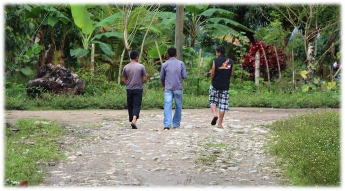 Three youth walk away from the grave of Gregorio Chávez near the community of La Panamá, Honduras, in 2013.