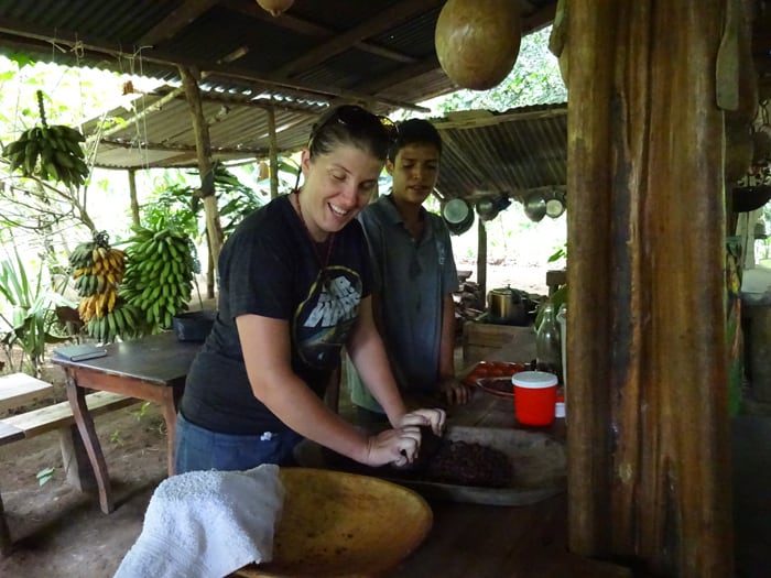 Shana Stratton of Smartsville, California, uses a stone to grind roasted cacao beans in order to remove the shells.