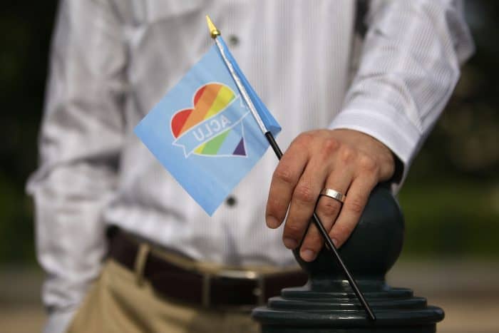 A man holds a rainbow flag in support of same-sex marriage.