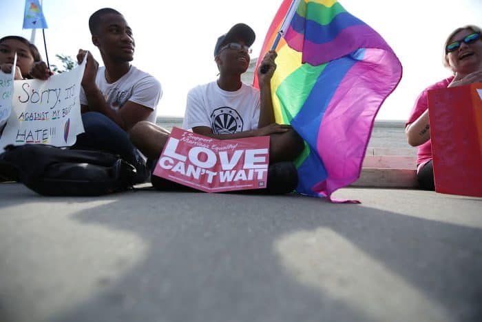 Local resident Carlos McKnight holds a rainbow flag in support of same-sex marriage