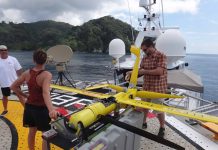 Charissa Moen of Precision Integrated and Andy Crafts of UAV manufacturer Aeroval inspect a Flexrotor drone during a test flight in Cocos Island in May, 2015.