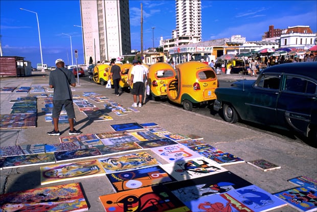 Paintings are spread out for sale at an outdoor flea market along Havana’s oceanfront Malecón, 2015.
