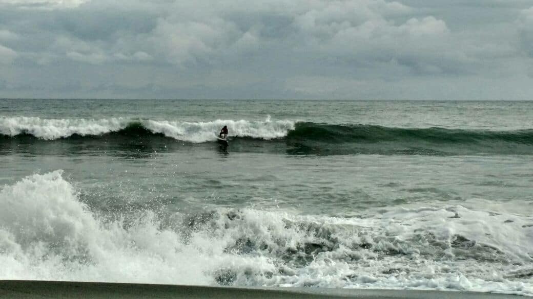 Surfer takes a wave at Playa Hermosa beach