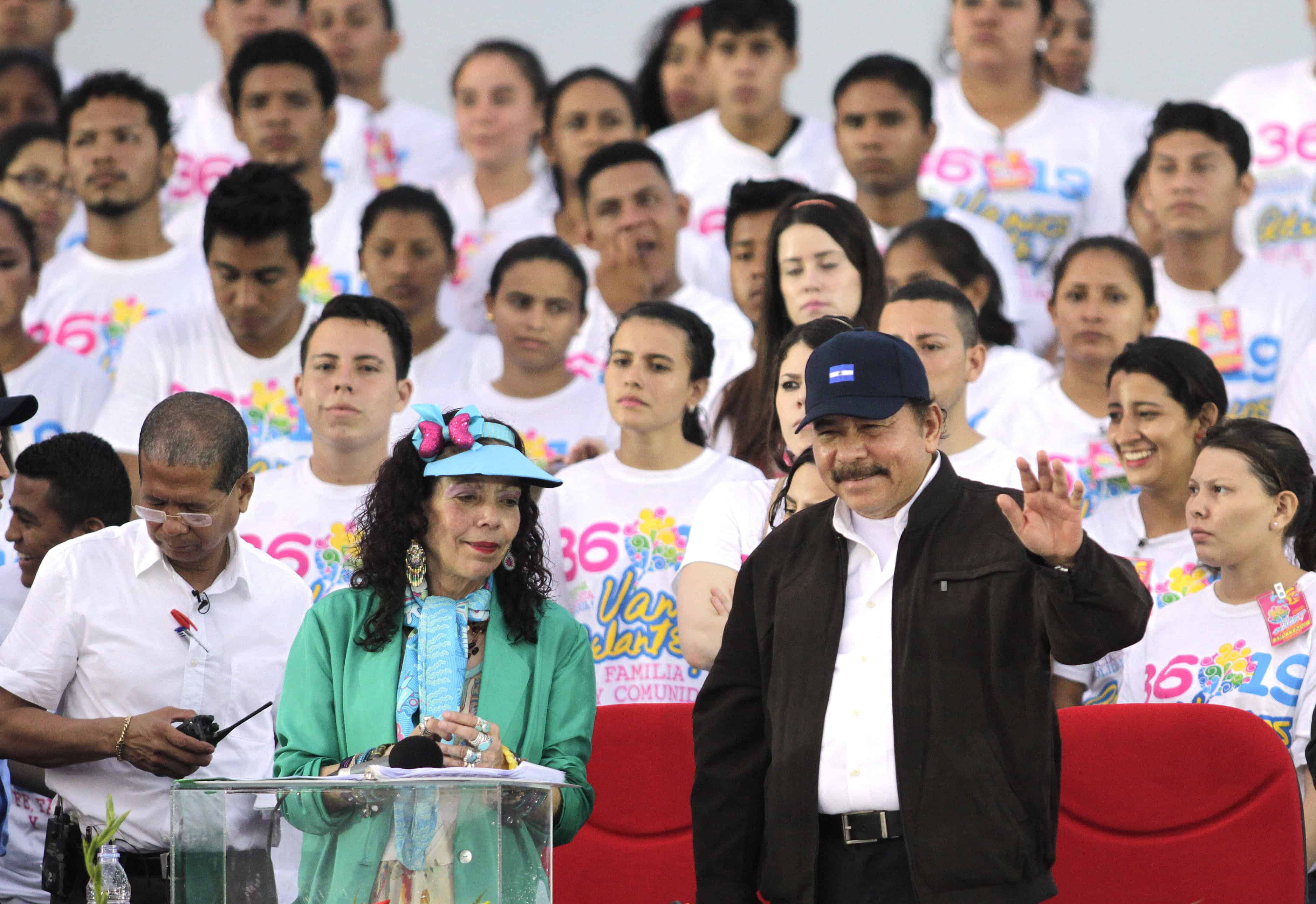 Nicaraguan President Daniel Ortega and First Lady Rosario Murillo wave to supporters during the celebration of the 36th anniversary of the Sandinista Revolution at La Fe square in Managua