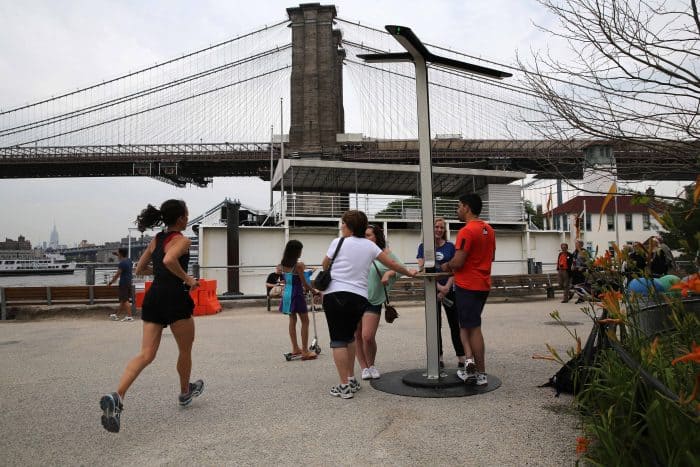 New Yorkers charge their cellphones at a free solar-powered charging station.