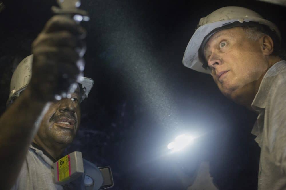 Miner Daniel Guerrero, left, shows a rock to Charles Burgess, director of Minería Texas Colombia in Muzo, Colombia on July 24, 2015. 