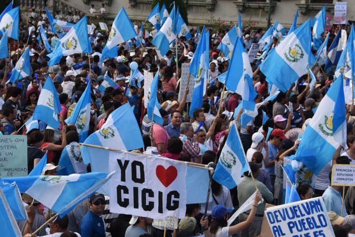 Protesters wave Guatemalan flags and a sign reading "I love CICIG."