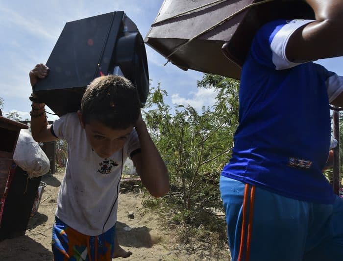 Colombians deported from Venezuela who returned for some of their belongings and crossed them through the bordering Táchira River, stand on the banks of the river in Cúcuta, on the Colombian side, on Aug. 25, 2015. 