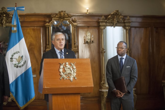 Molina, left, delivers a speech as U.S. Ambassador Todd Robinson looks on.