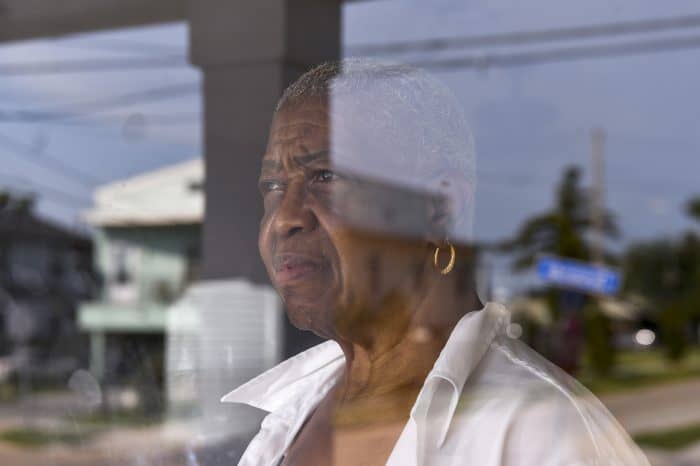 Velma Collins, 73, looks out her door. Her original house was destroyed during Hurricane Katrina, but she decided to rebuild and live on the same property. 