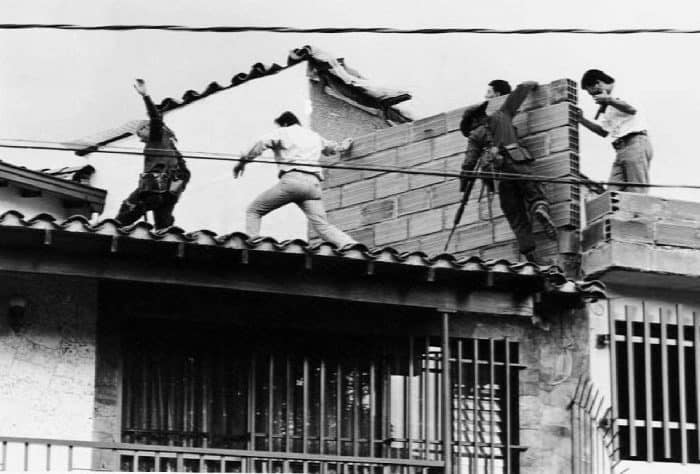 Colombian police and military forces storm the rooftop where drug lord Pablo Escobar was shot dead.