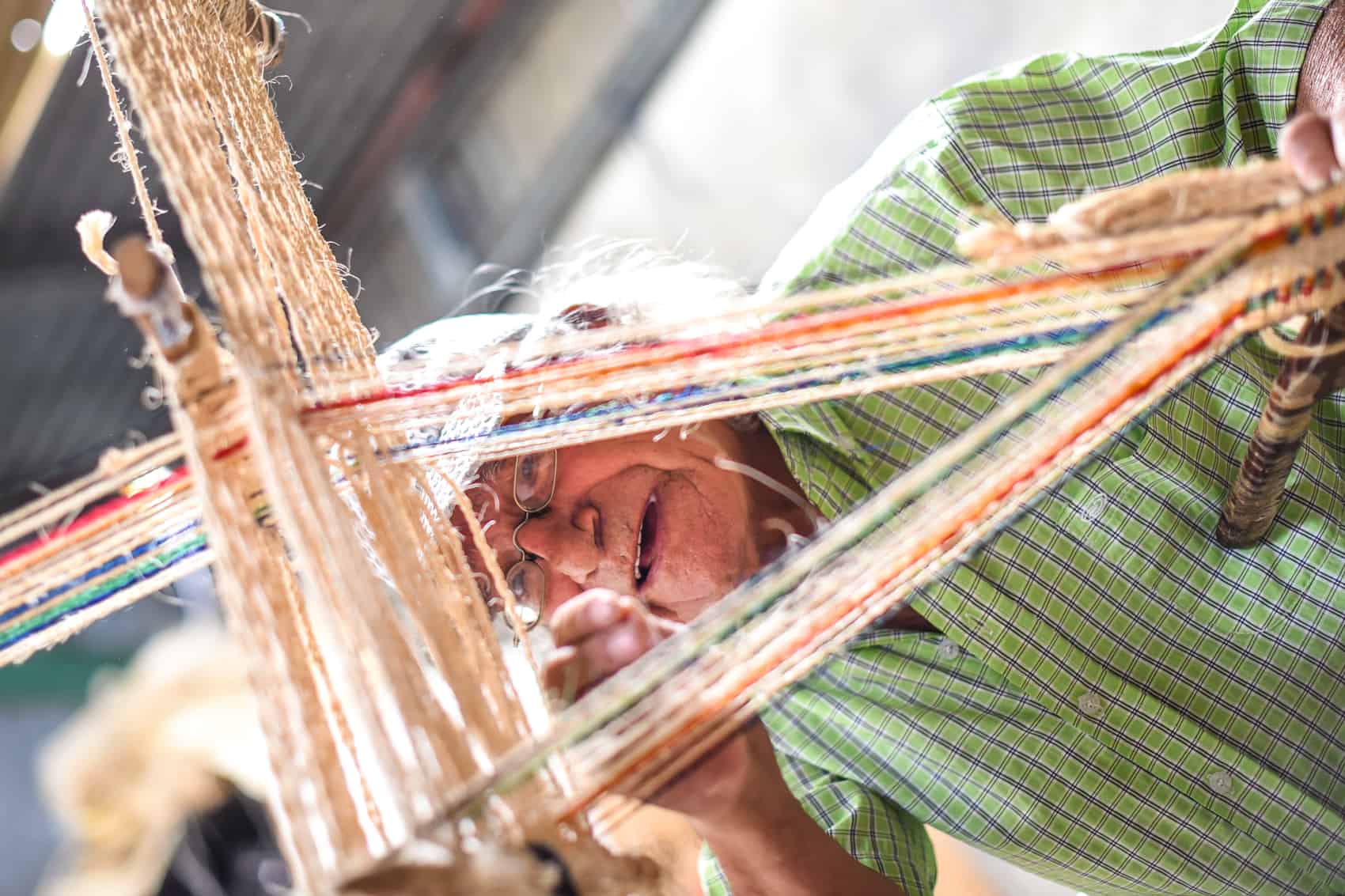 Juan Olivado Camacho, known as Don Tina, 74, explains how he uses a loom and cabuya thread to make products.